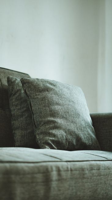 A comfortable gray sofa with cushions in a peaceful Jakarta living room setting.