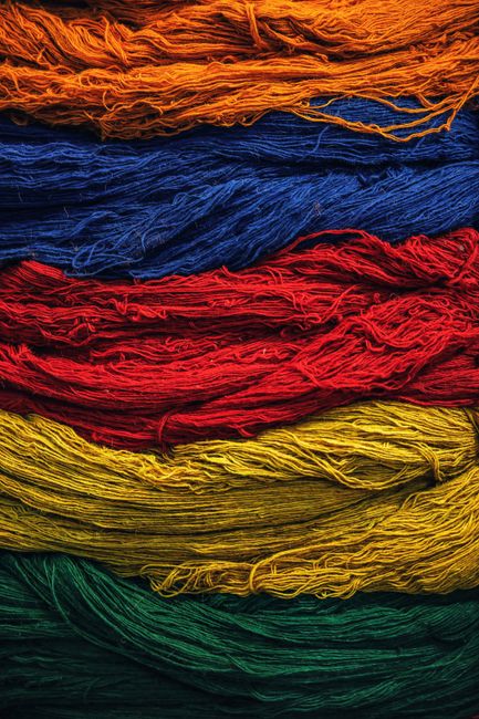 Bright multicolored textile threads arranged in layers, showcasing vivid colors and texture.