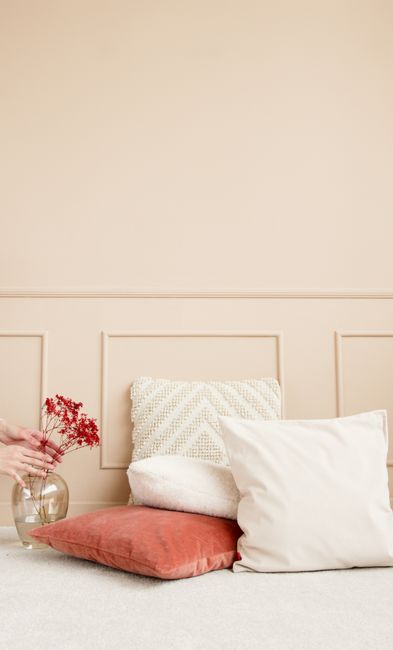 Elegant interior setting with soft cushions and a decorative vase in a minimalist design.